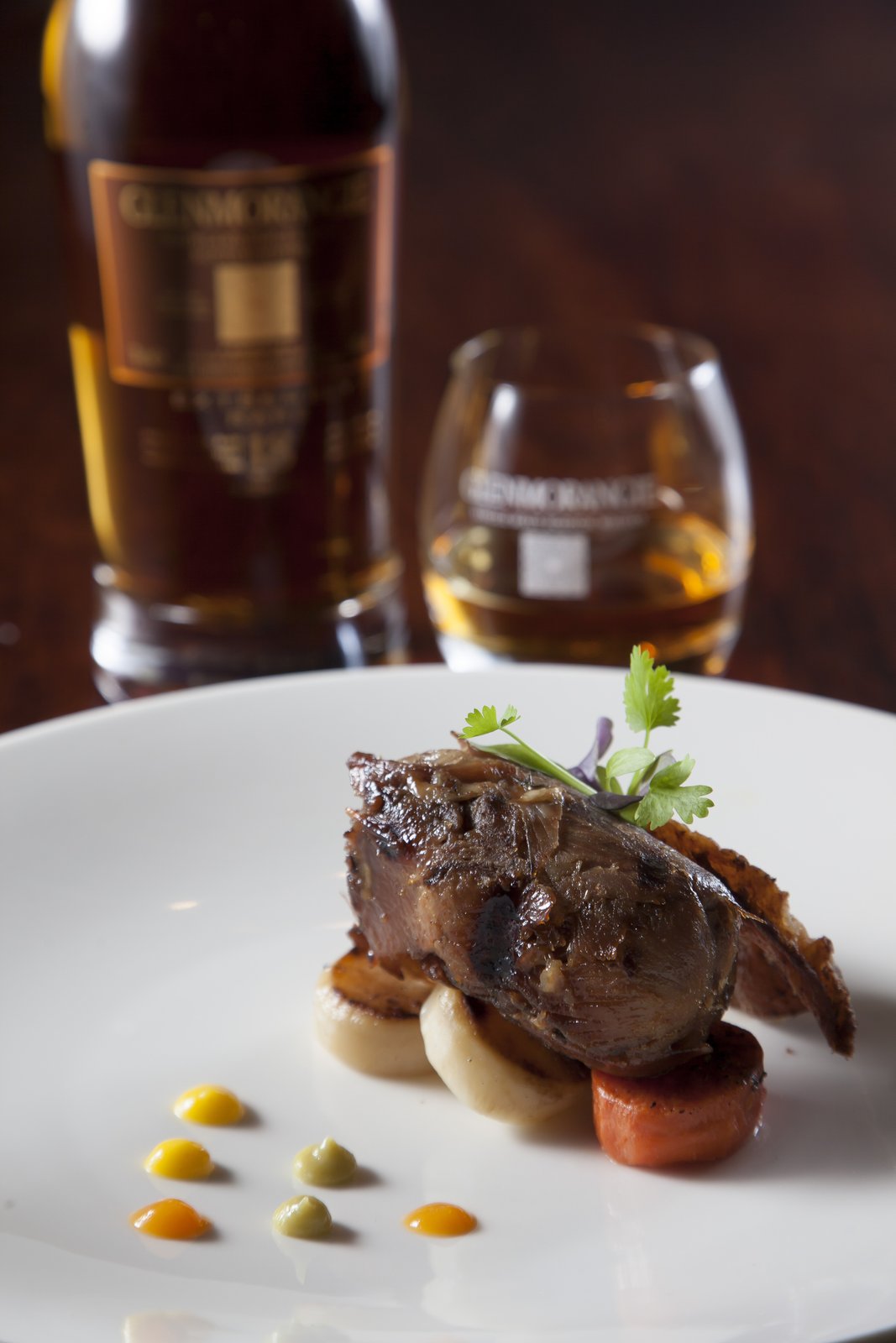 Charcoal-grilled duck leg with Enfin's honey-citrus reduction and fondant roots — paired with Glenmorangie 18 Years Old
