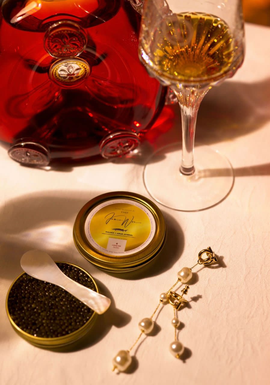 The James Won Custom Caviar tin beside a Louis XIII decanter and crystal wine glass at Shin'Labo - a Kaluga and Amur hybrid sturgeon caviar cured low in salinity for the cognac.