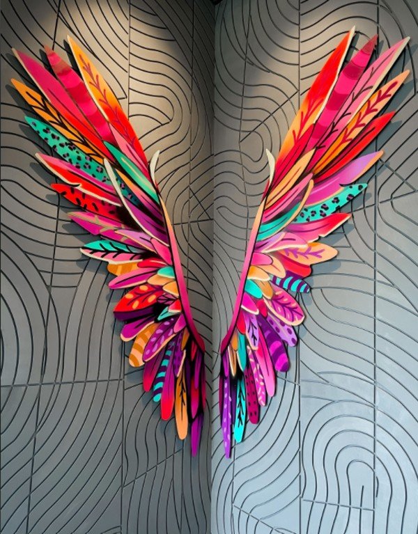 Bouchon Enfin — Kenji Chai's painted-feather wings installation on the grooved wall by the entrance.