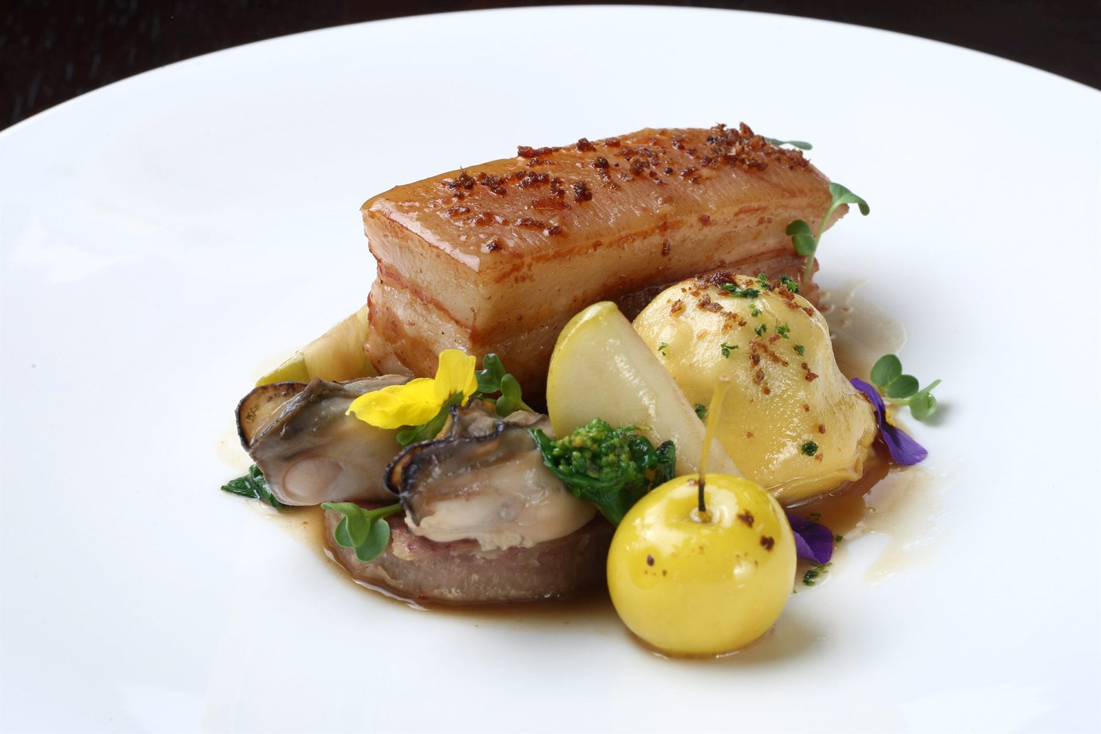 Confit pork belly in fermented red bean — raviolo of pork neck, oysters, apple.